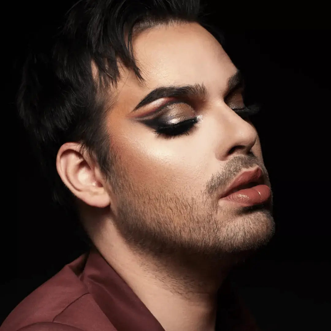 Personne au look glamour avec maquillage oculaire dramatique et barbe subtile, paillettes biodégradables Paillettes Runway