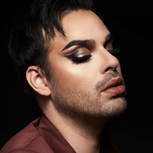 Personne au look glamour avec maquillage oculaire dramatique et barbe subtile, paillettes biodégradables Paillettes Runway
