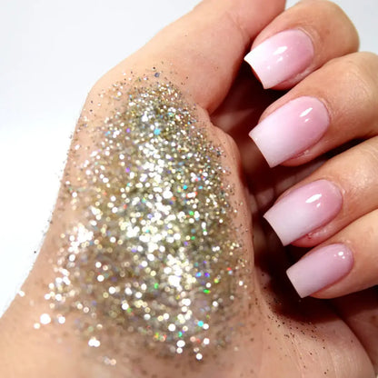 Main de paillettes biodégradables iridescentes et ongles ombré rose blanc pour un look glamour