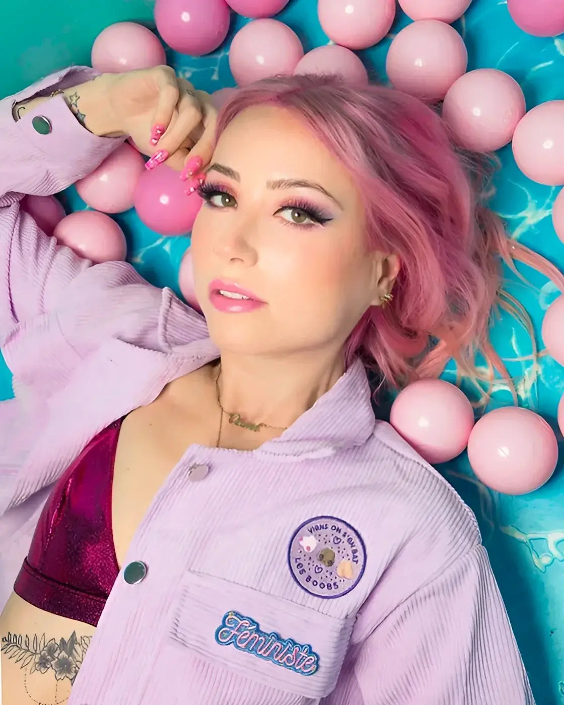 Femme aux cheveux roses en écusson féministe coloré avec détails scintillants