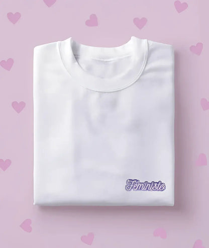 T-shirt blanc plié avec écusson féministe Féministe en violet scintillant
