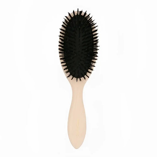 Petite brosse à cheveux avec poignée claire et poils noirs pour un geste simple