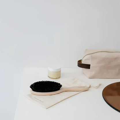 Petite brosse à cheveux en bois aux poils sombres pour soin capillaire