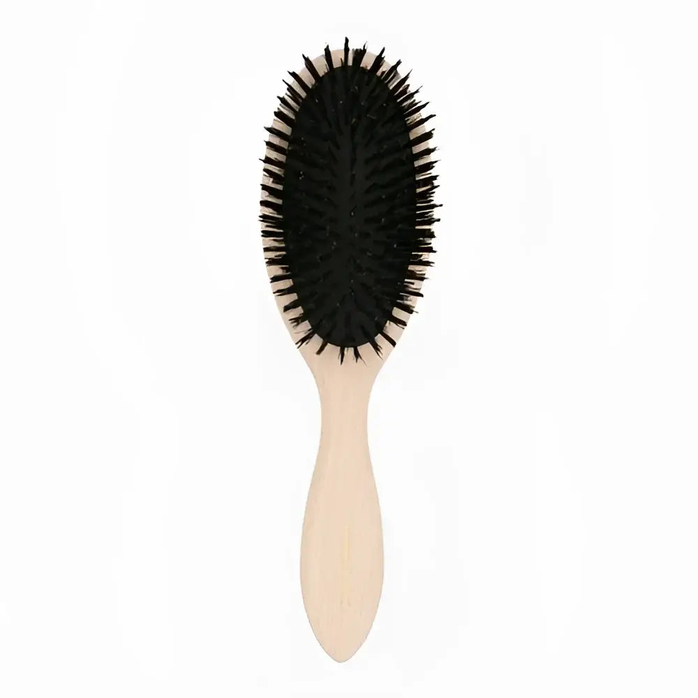 Brosse à cheveux ovale petite avec manche clair et poils noirs pour soin capillaire