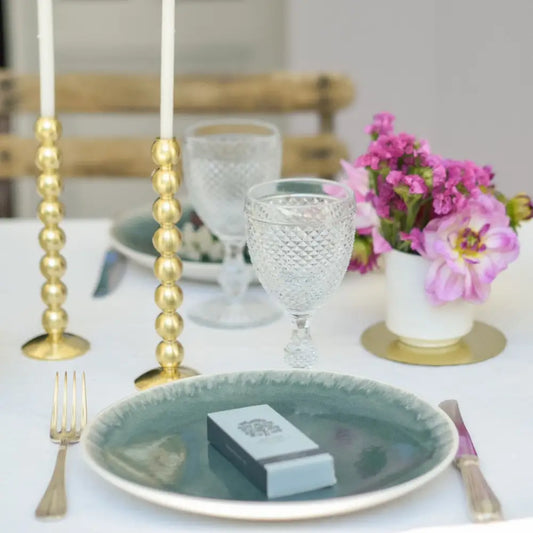 Table élégante avec petites allumettes vert céladon, design raffiné et fleurs violettes