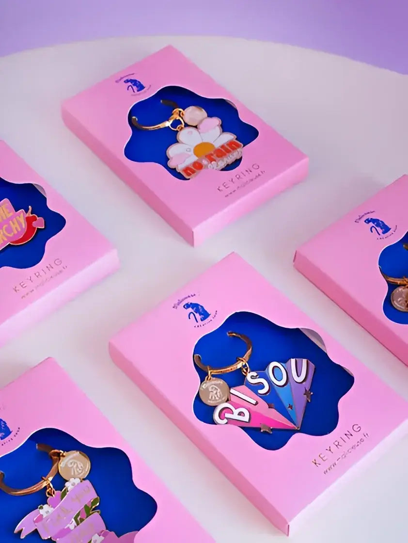 Porte-clé rebelle en rose avec pendentif marguerite coloré et message provocateur No Fear émaillé rouge