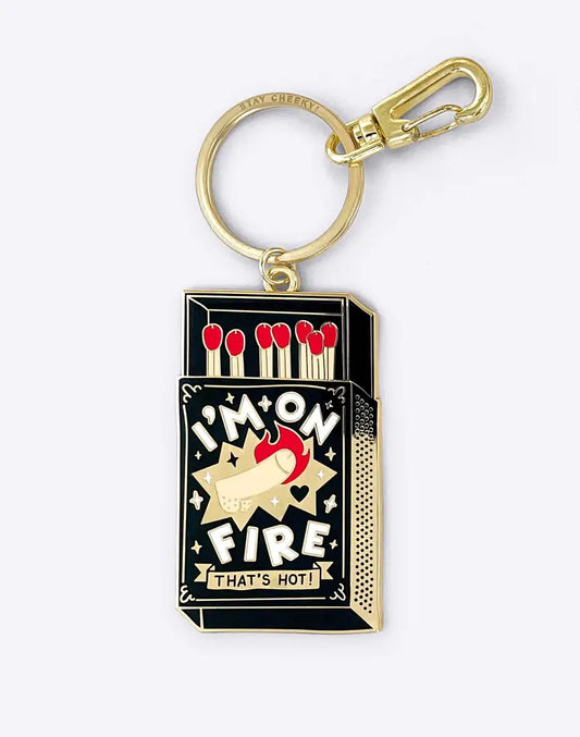 Porte-clés Porte-clés Je suis en feu : boite d’allumettes noire et or avec petite flamme rouge et slogan hot !