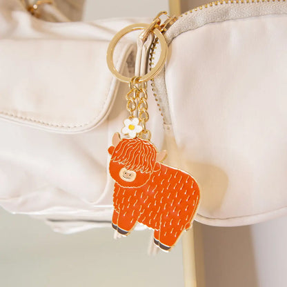 Porte-clés highland cow orange émaillé avec fleur blanche