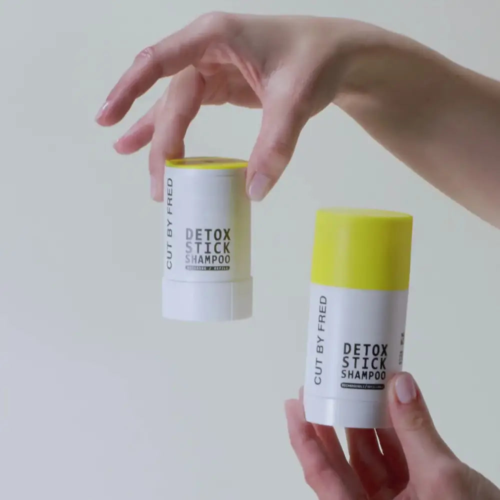 Deux mains tenant des sticks shampoing Detox pour cuir chevelu sensible