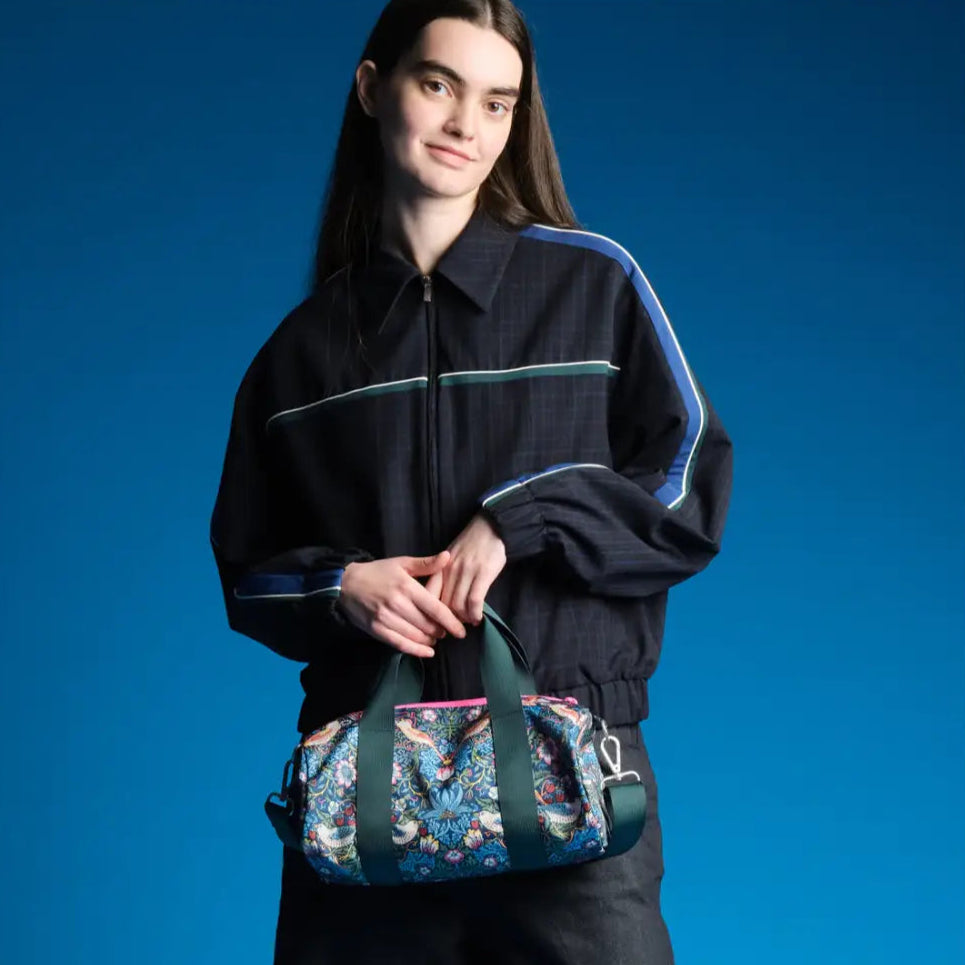 Femme avec sac week-end medium William Morris en tissu floral et veste bleu foncé