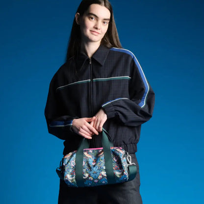 Femme avec sac week-end medium William Morris en tissu floral et veste bleu foncé