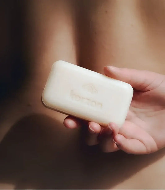 Main de femme tenant savon solide surgras parfum solaire 100g Le Soleil