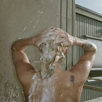 Personne lavant cheveux blonds au shampoing liquide bouleau