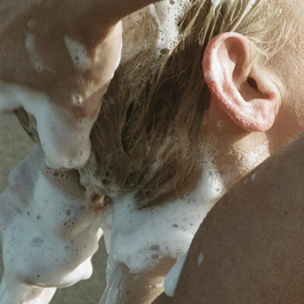 Tête et oreille couvertes de mousse de shampoing liquide bouleau pour chevelure plus saine