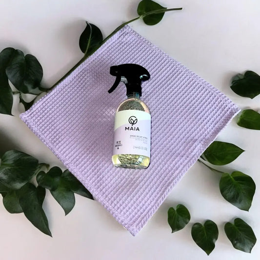 Spray nettoyant vitres 500 ml avec liquide jaune et plantes sur serviette violette