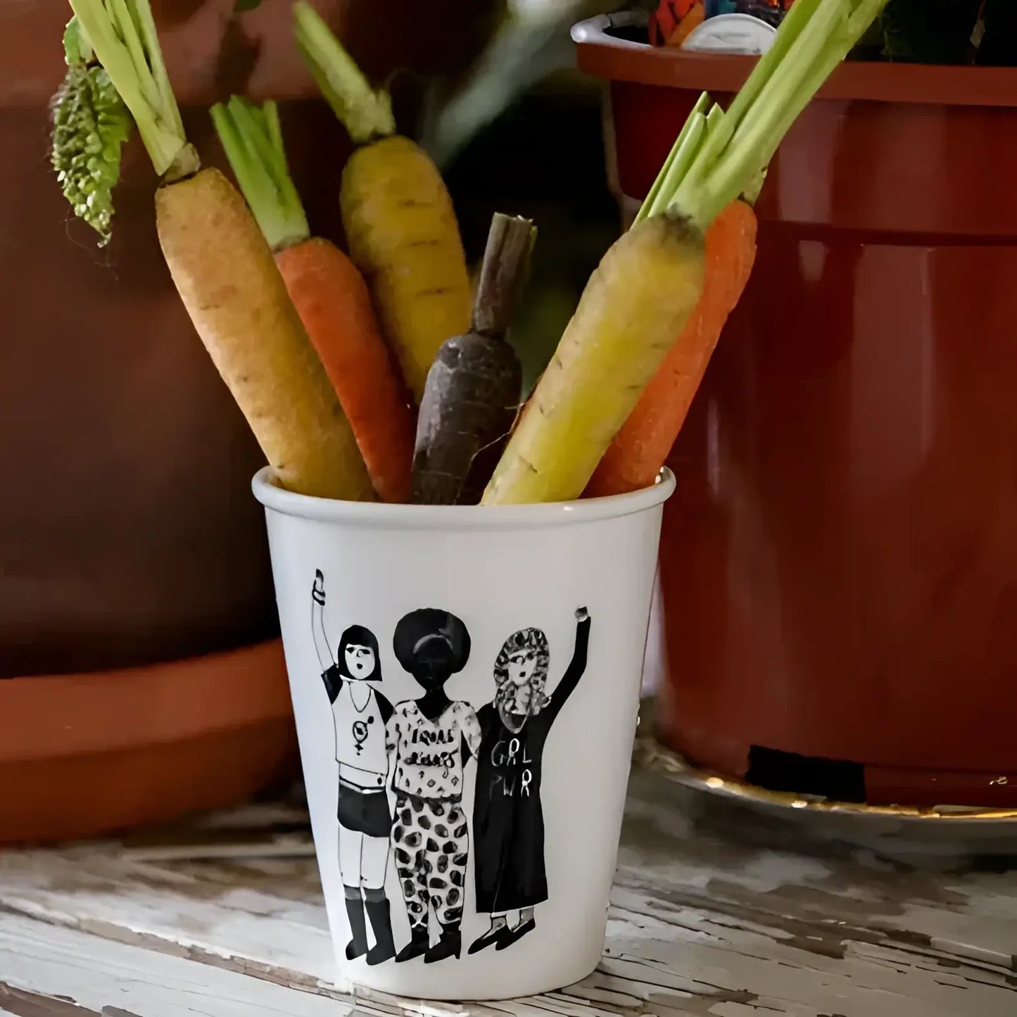Tasse Female Power avec carottes colorées sur fond blanc cassé