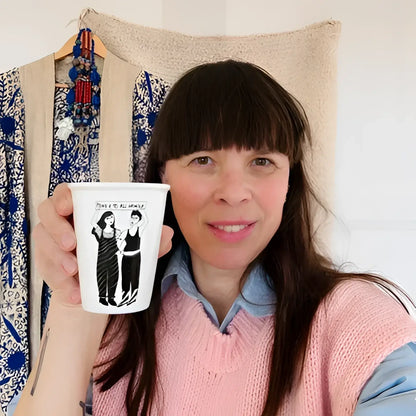 Femme tenant tasse engagée Power To All Women avec illustration de deux jeunes filles pour un avenir meilleur