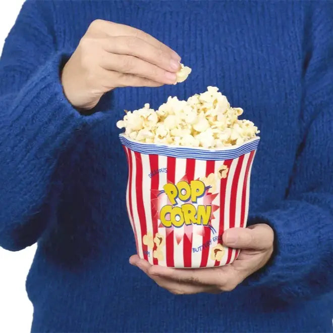 Personne tenant un seau à popcorn rayé rouge et blanc, ambiance cinéma humoristique