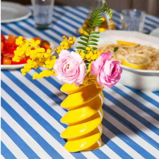 Vase fusilli vibrant avec roses roses et mimosa, plus qu’un simple vase floral