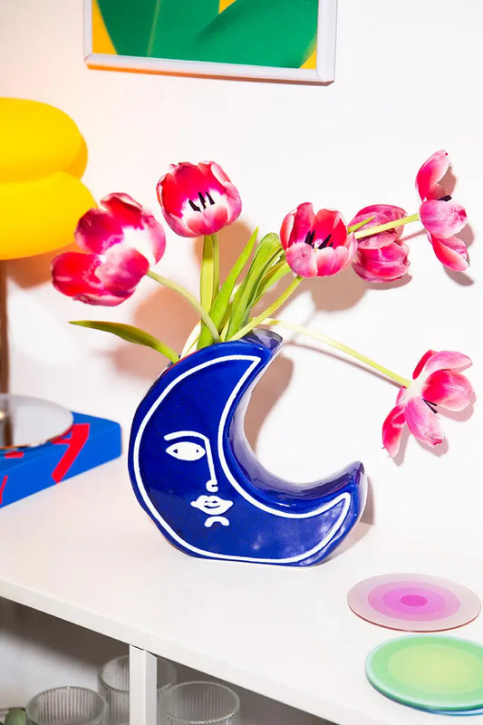 Vase Moon Évoque: vase céramique bleu lune croissante avec silhouette Évocatrice blanche tenant tulipes roses et rouges, idée cadeau
