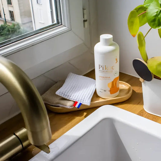 Bouteille blanche de liquide vaisselle avec étiquette orange pour vinaigre jasmin